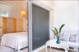 a bedroom with a bed and a window with a table at Yasos By The Sea in Çeşme