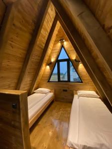 Schlafzimmer im Dachgeschoss mit 2 Betten und einem Fenster in der Unterkunft DANDELION HOUSE in Žabljak