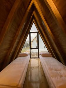two beds in a attic with a window at DANDELION HOUSE in Žabljak