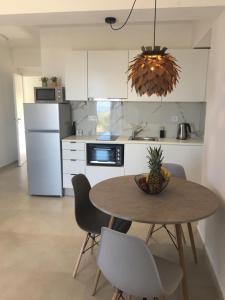uma cozinha com uma mesa com uma tigela de ananás em Blue View Suites em Chorafakia