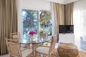 a dining room with a glass table and chairs at Yasos By The Sea in Çeşme