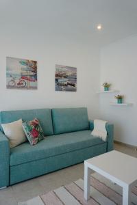 - un salon avec un canapé bleu et une table dans l'établissement Casa Barbosa, à Nazaré
