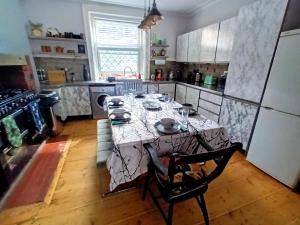 a kitchen with a table in the middle of it at 4 bedroom period Townhouse in the heart of Hebden in Hebden Bridge
