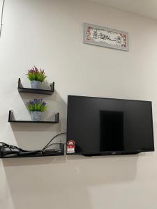 a flat screen tv sitting on top of a wall at HOMESTAY BANDAR KANGAR (NS FAMILY HOMESTAY) in Kangar