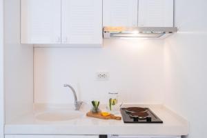 a white kitchen with a sink and a stove at Yasos By The Sea in Çeşme