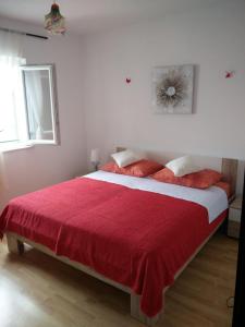 a bedroom with a large bed with a red blanket at Crni in Gdinj