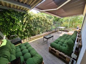 eine Terrasse mit grünen Sofas und einem Tisch in der Unterkunft Haus Mitten in Herzen von Günzburg in Günzburg