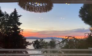 a view of a sunset from a house window at Yasos By The Sea in Çeşme