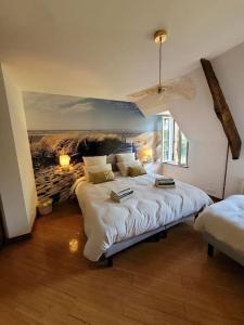 1 dormitorio con 2 camas y un cuadro en la pared en Gîte La Maison de Gouville, avec piscine et SPA, proche mer, en Gouville-sur-Mer