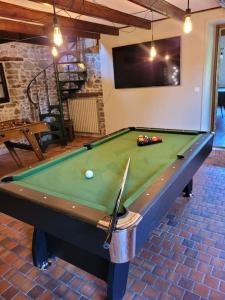 una mesa de billar en una sala de estar con accesorios en Gîte La Maison de Gouville, avec piscine et SPA, proche mer, en Gouville-sur-Mer