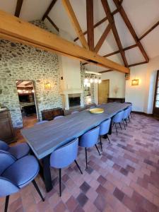 una gran mesa de madera y sillas en una habitación en Gîte La Maison de Gouville, avec piscine et SPA, proche mer, en Gouville-sur-Mer