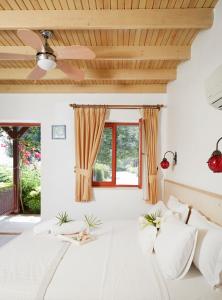 a bedroom with a white bed with a ceiling at Flow Datca Surf & Beach Hotel in Datca