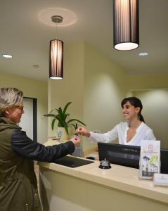 two women standing at a reception desk in an office at Hotel Am Schlosstor in Bückeburg