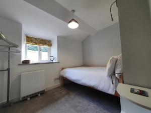 a small bedroom with a bed and a window at No8 3 bed cottage Winter Deals offered 3 nights or more Nov-Mar in Backbarrow +12 photos