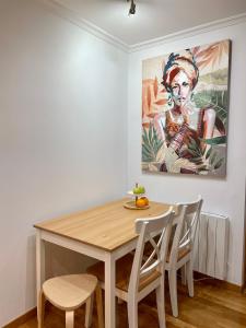 une table à manger avec des chaises et un tableau mural dans l'établissement A Das Marias GALLERY, à Ourense