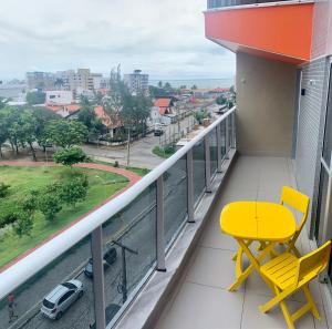 uma cadeira amarela numa varanda com vista para a cidade em Villi 503C em João Pessoa