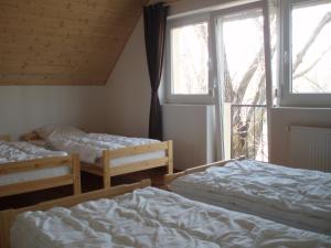two beds in a room with a window at Balaton Villa in Gyenesdiás