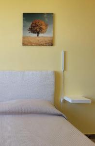 a bedroom with a bed with a tree on the wall at Pepe rosa in Termoli