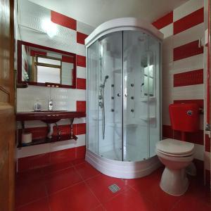 baño rojo y blanco con ducha y aseo en Lavender Apartments en Sînpetru