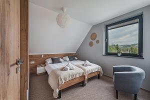 a bedroom with a bed and a window and a chair at Siedlisko Szlachtowskie in Szczawnica