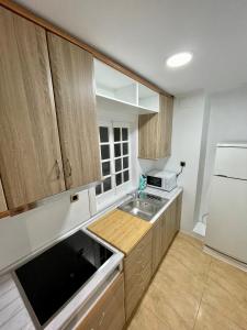 - une cuisine avec des placards en bois et un réfrigérateur blanc dans l'établissement A Das Marias GALLERY, à Ourense