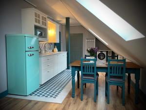 a kitchen with a table and a blue refrigerator at TGM Apartments in Český Krumlov