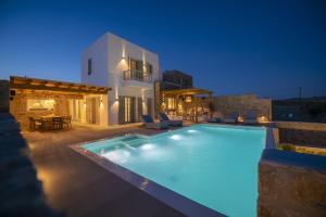 a villa with a swimming pool at night at Summer Breeze Luxury Villa Mykonos in Panormos Mykonos