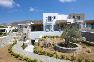 una casa con un jardín delante de ella en Summer Breeze Luxury Villa Mykonos, en Panormos  Mykonos