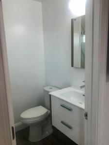 bagno bianco con servizi igienici e lavandino di Safari Apartments a Ocean City