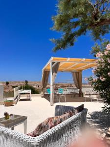 un patio con dosel, mesa y sillas en Masseria OSTUNI MARE Agri Resort en Ostuni