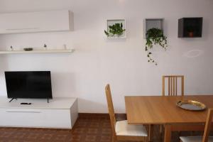 a living room with a tv and a dining room table at Spazioso appartamento (FREE PARKING) in Castel di Leva