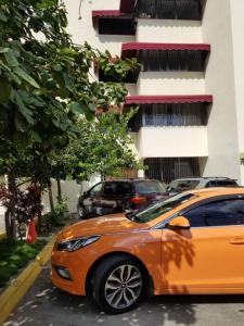 un coche naranja estacionado frente a un edificio en Apartamento acogedor con equipamiento premium, en El Café