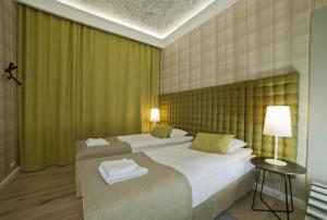 a bedroom with two beds and a table with a lamp at Patio Apartments - Old Town in Gdańsk