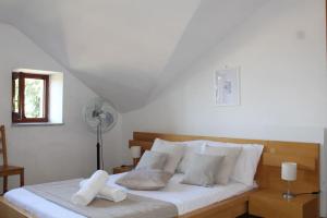 1 dormitorio con 1 cama con sábanas blancas y ventilador en Spazioso appartamento (FREE PARKING), en Castel di Leva