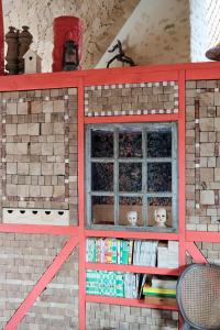 um edifício de tijolos com uma janela e livros em AU LIT ON DORT - Logis de Village em Bellême