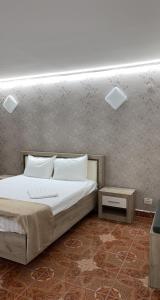 ein Schlafzimmer mit einem weißen Bett und einer Wand in der Unterkunft Dany Holiday in Eforie Nord