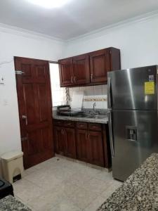 a kitchen with a stainless steel refrigerator and wooden cabinets at Apartamento acogedor con equipamiento premium in El Café