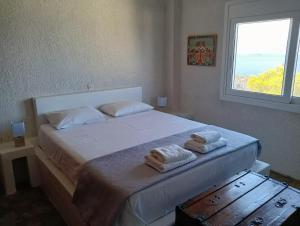 a bedroom with a white bed with towels on it at Villa Karla in Pefkali