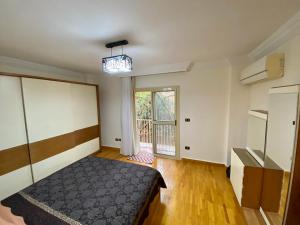 a bedroom with a bed and a large window at Golden Rose- men only in 6th Of October