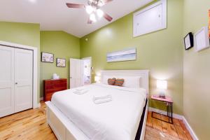 um quarto com uma cama branca e paredes verdes em Rising Tide Cottage em Cushing