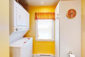 une petite cuisine avec des murs jaunes et une fenêtre dans l'établissement Rising Tide Cottage, à Cushing 20 autres photos