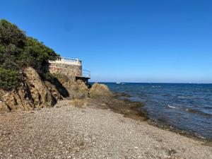 una spiaggia rocciosa vicino all'oceano con un faro di Saint Aygulf - a 250m de la mer- 3 pieces 45m2 a Saint-Aygulf