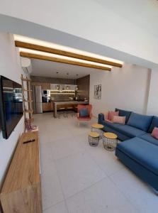 a living room with a blue couch and a table at Courtyard Luxury Suites “MARIANTHI” in Pefki Rhodes