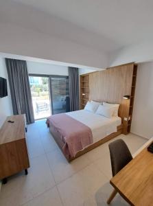 1 dormitorio con cama, mesa y escritorio en Courtyard Luxury Suites “MARIANTHI”, en Pefki