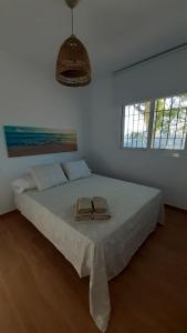 - une chambre blanche avec un grand lit et 2 chaussons dans l'établissement Apartamento Alegría, à Frigiliana