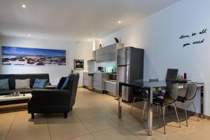 a kitchen and living room with a table and a refrigerator at Bubali Luxury Apartments - Adults Only - Wheelchair Friendly in Palm-Eagle Beach