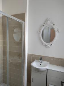 a bathroom with a shower and a sink and a mirror at Lovely refurbished apartments, Morecambe Promenade in Morecambe +25 photos