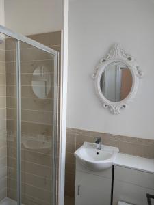 a bathroom with a shower and a sink and a mirror at Lovely refurbished apartments, Morecambe Promenade in Morecambe