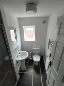 a bathroom with a white toilet and a sink at Lovely refurbished apartments, Morecambe Promenade in Morecambe