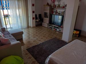 sala de estar con sofá y TV en stanza vista mare en Giardini Naxos